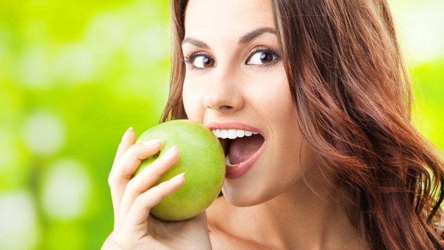 Девушка ест яблоко