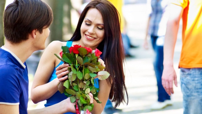 Парень дарит девушке цветы