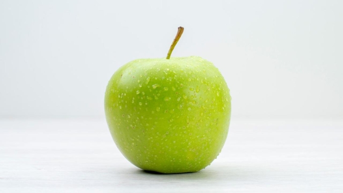 Зеленое яблоко на белом фоне